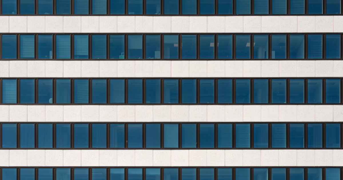 A fragment of the facade of a modern office building. Windows and light decorative stone. Organization of workplaces